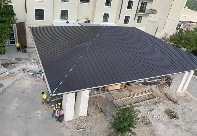 Metal roofing installation team working on a commercial building in Hempstead